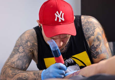 Krakow, Poland - June 11, 2022: 15th Tattoofest in Cracow. One of the most prestigious tattoo festivals. Tattoo artist at work. The process of tattooing.のeditorial素材