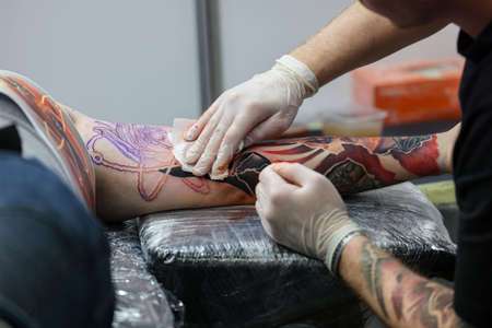 Krakow, Poland - June 11, 2022: 15th Tattoofest in Cracow. One of the most prestigious tattoo festivals. Tattoo artist at work. The process of tattooing.のeditorial素材
