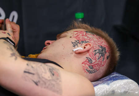 Krakow, Poland - June 11, 2022: 15th Tattoofest in Cracow. One of the most prestigious tattoo festivals. The process of tattooing.のeditorial素材