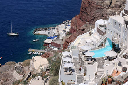 Oia, Santorini, Greece - July 3, 2021: Whitewashed houses with terraces and pools and a beautiful view in Oia on Santorini island, Greeceのeditorial素材