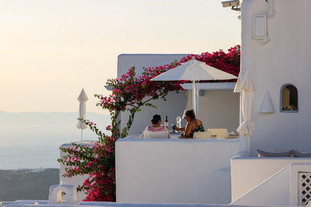 Imerovigli, Santorini, Greece - June 29, 2021: Red bougainvillea climbing on the wall of whitewashed house in Imerovigli on Santorini island, Cyclades, Greeceのeditorial素材