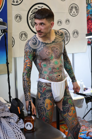 Krakow, Poland - June 11, 2022: Unidentified participant at 15th Tattoofest Convention in Cracow. One of the most prestigious tattoo festivals. Tattoo artist at work.のeditorial素材