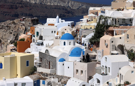 Oia, Santorini, Greece - July 3, 2021: Whitewashed buildings on the edge of the caldera cliff in Oia village, Santorini, Greeceのeditorial素材