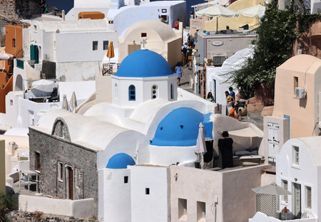 Oia, Santorini, Greece - July 3, 2021: Whitewashed buildings on the edge of the caldera cliff in Oia village, Santorini, Greeceのeditorial素材