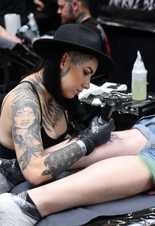 Krakow, Poland - June 12, 2022: Unidentified participant at 15th Tattoofest Convention in Cracow. Tattoo artist at work.のeditorial素材