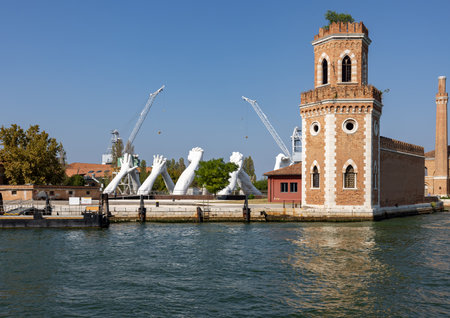 Venice, Italy - September 6, 2022: Giant joined hands sculpture Building Bridges by Lorenzo Quinn. Exhibition at Arsenale, Castello, Veniceのeditorial素材
