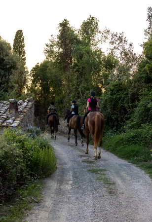 Montemassi, Italy - September 13, 2022: A woman and two girls during a horseback ride on a gravel road in Montemassi, Italyのeditorial素材