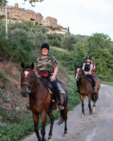 Montemassi, Italy - September 13, 2022: A woman and two girls during a horseback ride on a gravel road in Montemassi, Italyのeditorial素材