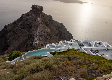 Imerovigli, Santorini, Greece - July 1, 2021: Tables on the restaurant terrace with a picturesque view of the sunset in Imerovigli. Santorini, Greece.のeditorial素材