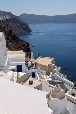 Oia, Santorini, Greece - July 3, 2021: Whitewashed houses with terraces and pools and a beautiful view in Oia on Santorini island, Greeceのeditorial素材