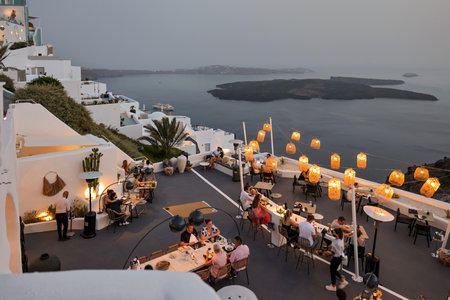 Imerovigli, Santorini, Greece - July 1, 2021: People having a romantic dinner on the panoramic terrace of a restaurant in Imerovigli, Santorini. Greeceのeditorial素材