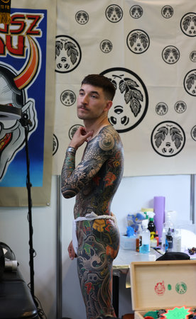 Krakow, Poland - June 11, 2022: Unidentified participant at 15th Tattoofest Convention in Cracow. One of the most prestigious tattoo festivals. Tattoo artist at work.のeditorial素材