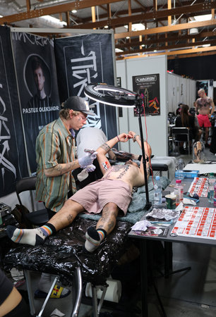 Krakow, Poland - June 12, 2022: Unidentified participant at 15th Tattoofest Convention in Cracow. One of the most prestigious tattoo festivals. Tattoo artist at work.のeditorial素材
