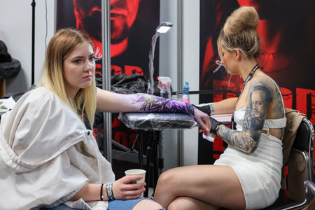 Krakow, Poland - June 12, 2022: Unidentified participant at 15th Tattoofest Convention in Cracow. Tattoo artist at work.のeditorial素材