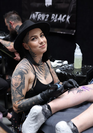 Krakow, Poland - June 12, 2022: Unidentified participant at 15th Tattoofest Convention in Cracow. Tattoo artist at work.のeditorial素材
