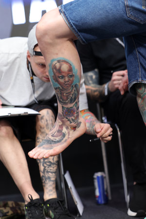 Krakow, Poland - June 11, 2022: Unidentified participant during the contest for the best tattoo at the 15th Tattoofest Convention in Cracow. One of the most prestigious tattoo festivals.のeditorial素材