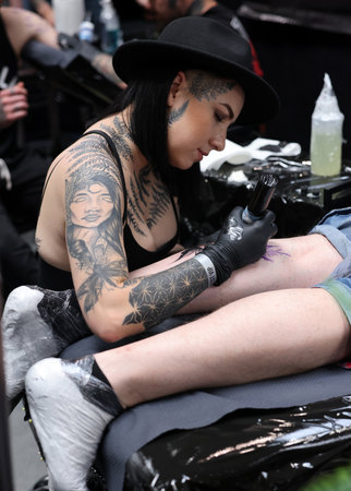 Krakow, Poland - June 12, 2022: Unidentified participant at 15th Tattoofest Convention in Cracow. Tattoo artist at work.のeditorial素材
