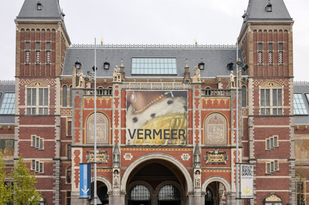 Amsterdam, Netherlands - April 21, 2023: Facade of the Rijksmuseum Dutch national museum with a banner advertising a special exhibition of Vermeers paintingsのeditorial素材