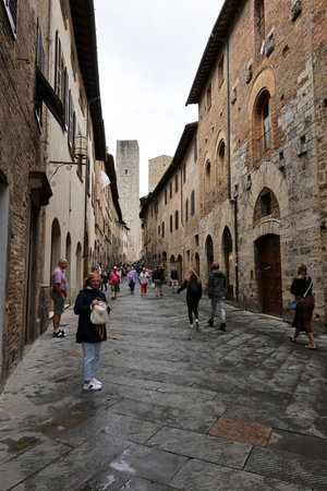 San Gimignano, Italy - Sept 17, 2022: Crowds of tourists on Via San Giovanni in the medieval town of San Gimignano. Tuscany, Italyのeditorial素材