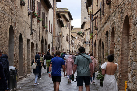 San Gimignano, Italy - Sept 17, 2022: Crowds of tourists on Via San Giovanni in the medieval town of San Gimignano. Tuscany, Italyのeditorial素材