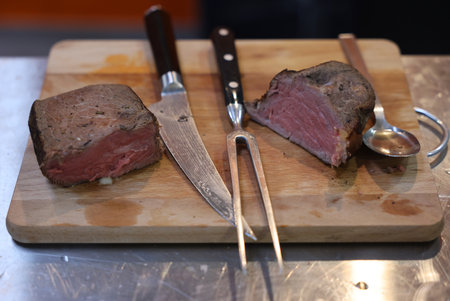Grilled beef tenderloin on a wooden kitchen board, ready to eatの写真素材