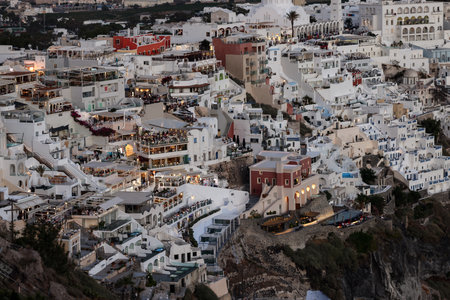 Fira, Santorini, Greece - June 27, 2021: Illuminated balcony decks and patios with restaurants of Fira town on Santorini island. Cyclades, Greeceのeditorial素材