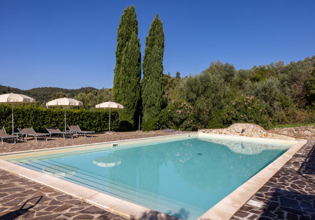 A swimming pool on the Montemassi hillside surrounded by cypresses and oleanders in the province of Grosseto. Italyの写真素材