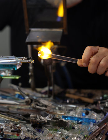 Glassworker while shaping the glass with a very high temperature flame in its artisan workshop in Venice. Italyの写真素材