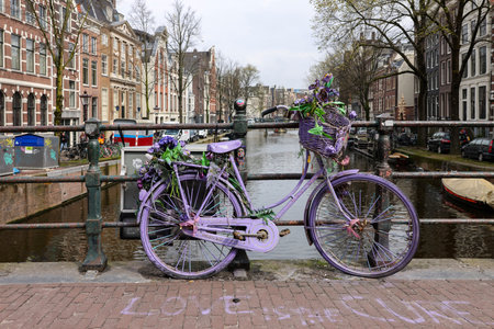 Amsterdam, Netherlands - April 21, 2023: Old lavender colored bicycle on the bridge in De Wallen - called the red light district. It is famous for its entertainment characterのeditorial素材