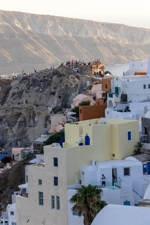 Oia, Santorini, Greece - June 28, 2021: Whitewashed buildings and the ruins of Castle of Agios Nikolaos on the edge of the caldera cliff, Oia village, Santorini, Greeceのeditorial素材