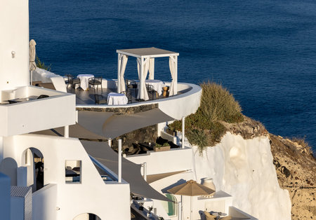 Oia, Santorini, Greece - June 28, 2021: Whitewashed houses with terraces and pools and a beautiful view in Oia on Santorini island, Greeceのeditorial素材