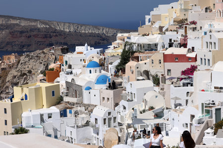 Oia, Santorini, Greece - July 3, 2021: Whitewashed buildings on the edge of the caldera cliff in Oia village, Santorini, Greeceのeditorial素材