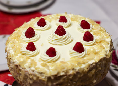 A delicious and tempting cake decorated with almonds and raspberriesの写真素材