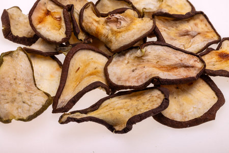 Closeup of a pile of dried slices of pears isolated on a white background. Healthy raw vegetarian eat from thin fruit chips of sweet and sour flavorの写真素材