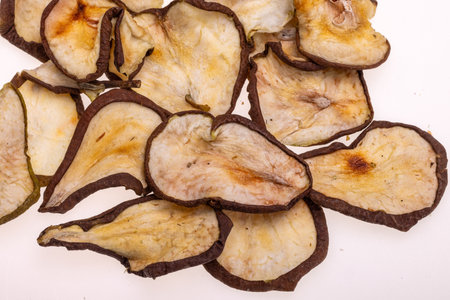 Closeup of a pile of dried slices of pears isolated on a white background. Healthy raw vegetarian eat from thin fruit chips of sweet and sour flavorの写真素材