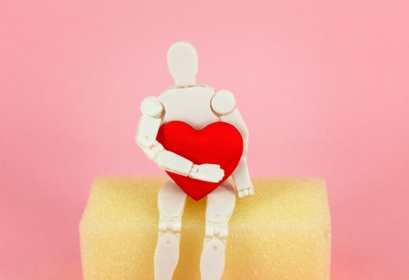 toy man holding a red heart shaped の写真素材
