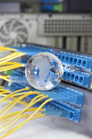globe with network cables and servers in a technology data center の写真素材