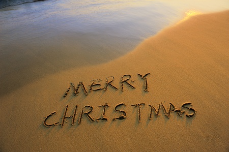Merry Christmas handwritten in sand on a beautiful beachの写真素材