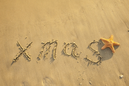 Merry Christmas handwritten in sand on beach の写真素材