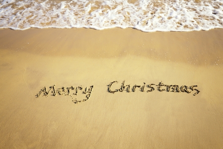 Merry Christmas handwritten in sand on a beautiful beachの写真素材