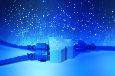 network cables and hub closeup with fiber optical backgroundの写真素材