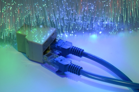 network cables and hub closeup with fiber optical backgroundの写真素材