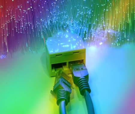 network cables and hub closeup with fiber optical backgroundの写真素材