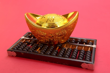 Chinese gold ingot and abacus mean symbols of wealth and prosperity.の写真素材
