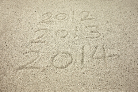 Year 2014 hand written on the white sand in front of the seaの写真素材