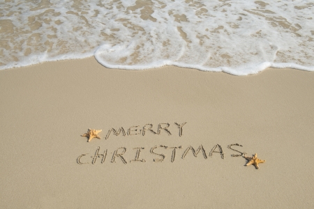 Merry Christmas handwritten in sand on a beautiful beachの写真素材