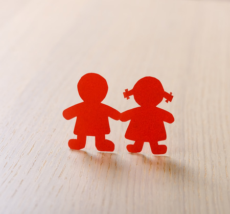 Silhouettes of men, women cut out of paper on a woodenの写真素材