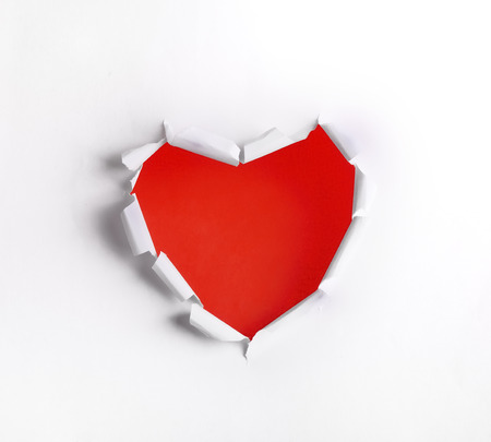 Heart shaped hole in white paper with red blank spaceの写真素材