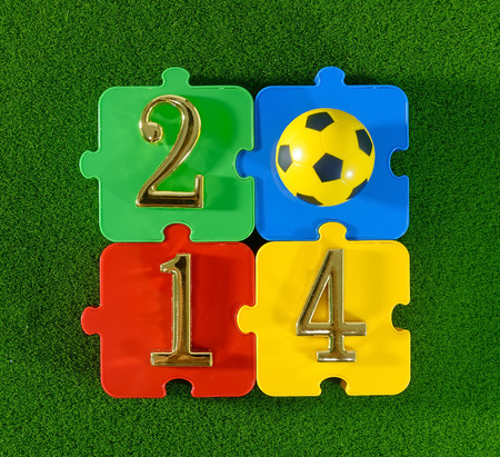 2014 message make of metal numbers and football soccer ball on grass background with puzzleの写真素材