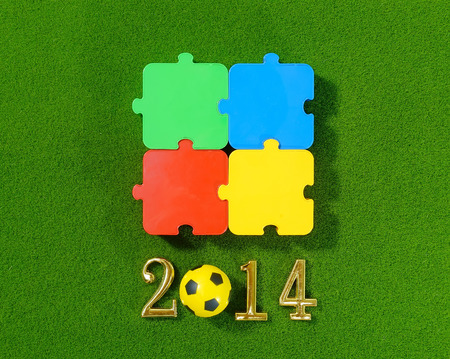 2014 message make of metal numbers and football soccer ball on grass background with puzzleの写真素材